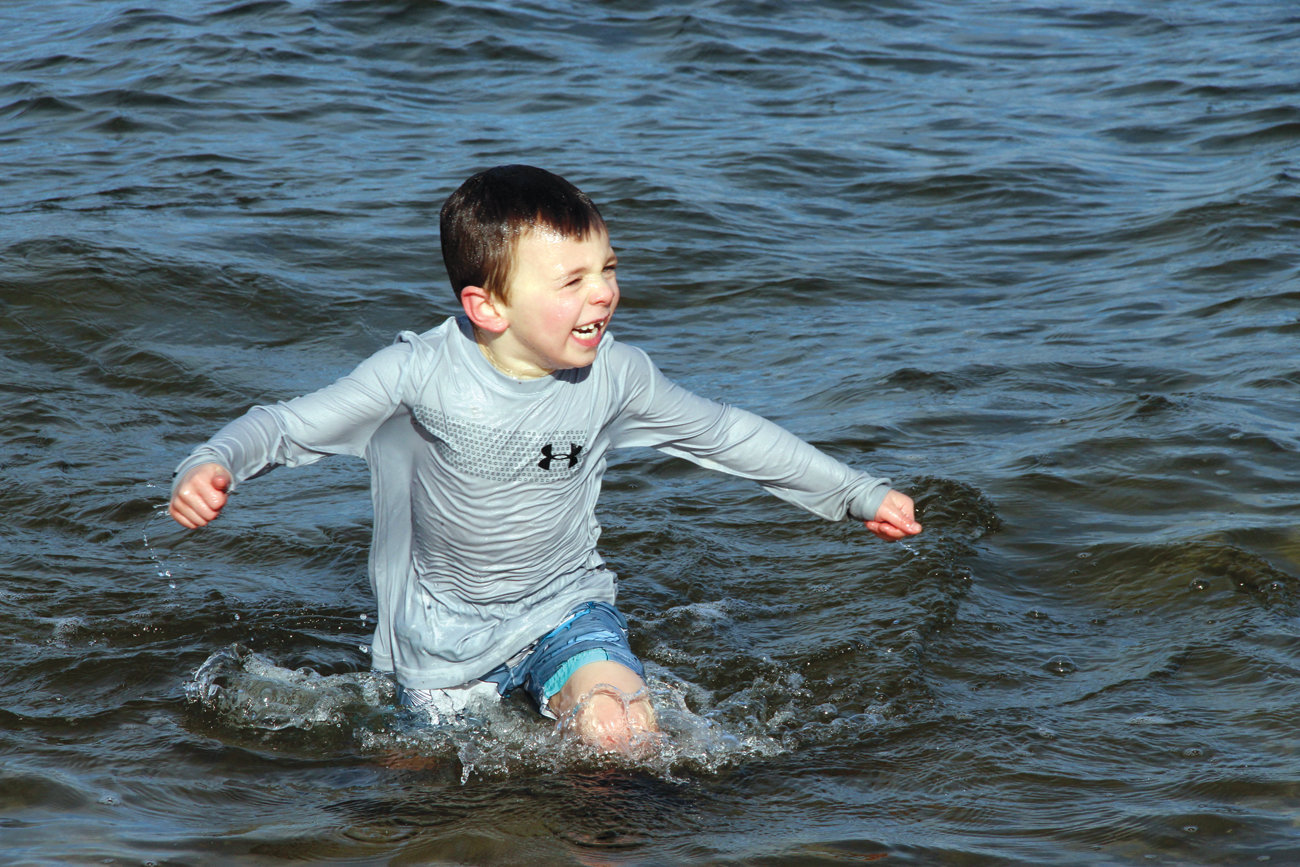 RUNNER AND PLUNGER: Luke McGowan, son of Ryan and Laurie McGowan of Laid-back Fitness that co-hosted the event for the benefit of Mentor RI, emerges from bay waters.